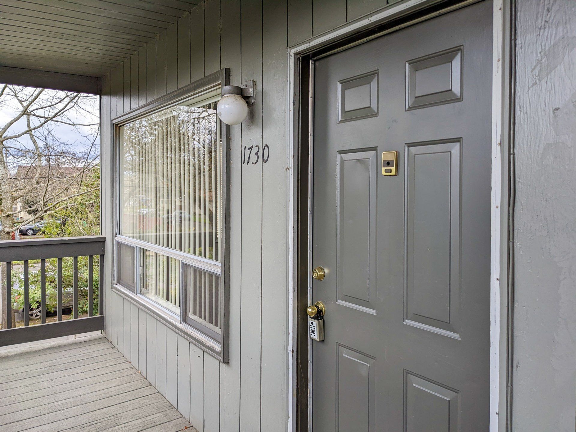 The front door of a house with a balcony and a window.