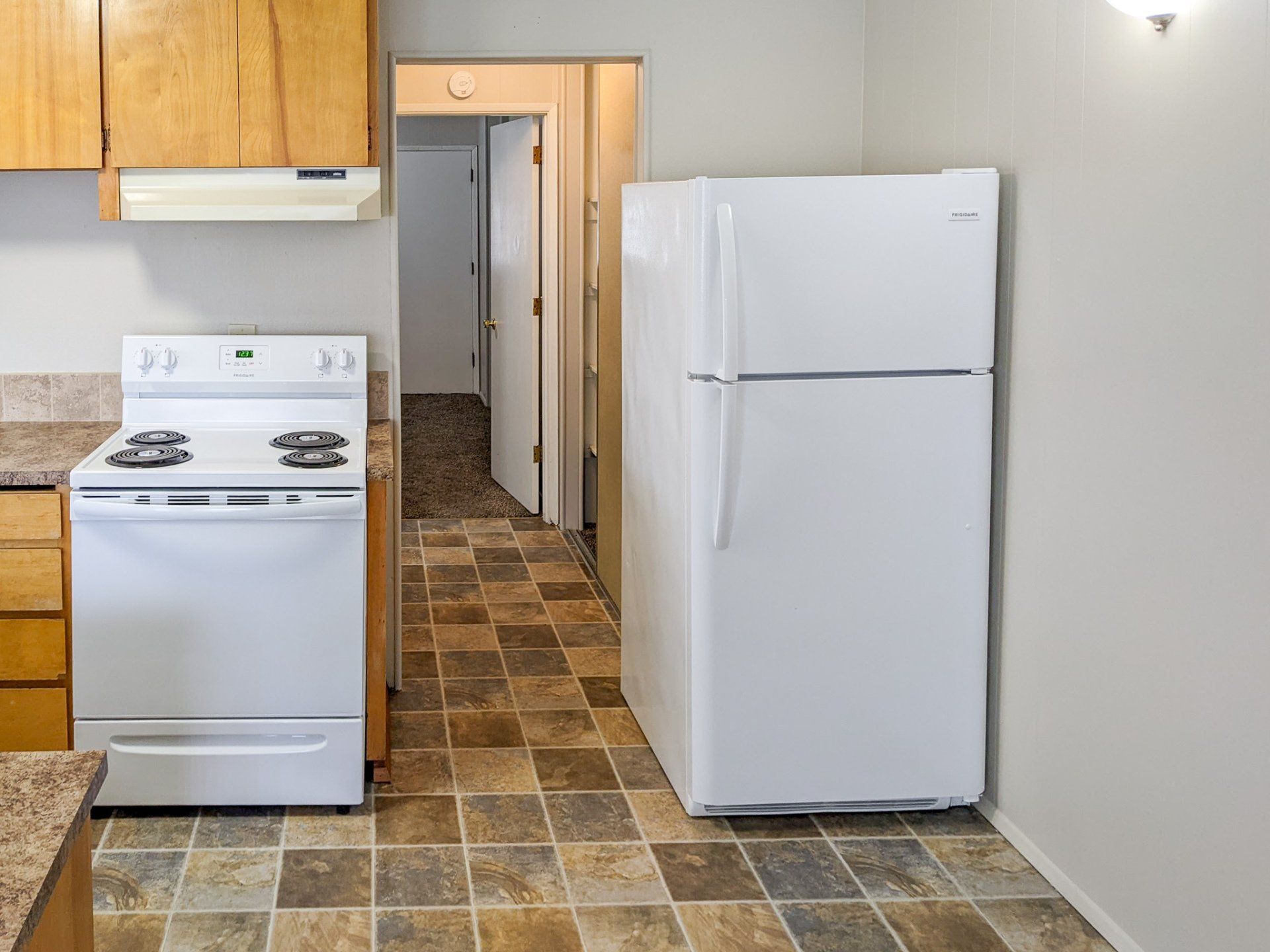 A kitchen with a stove top oven and a refrigerator