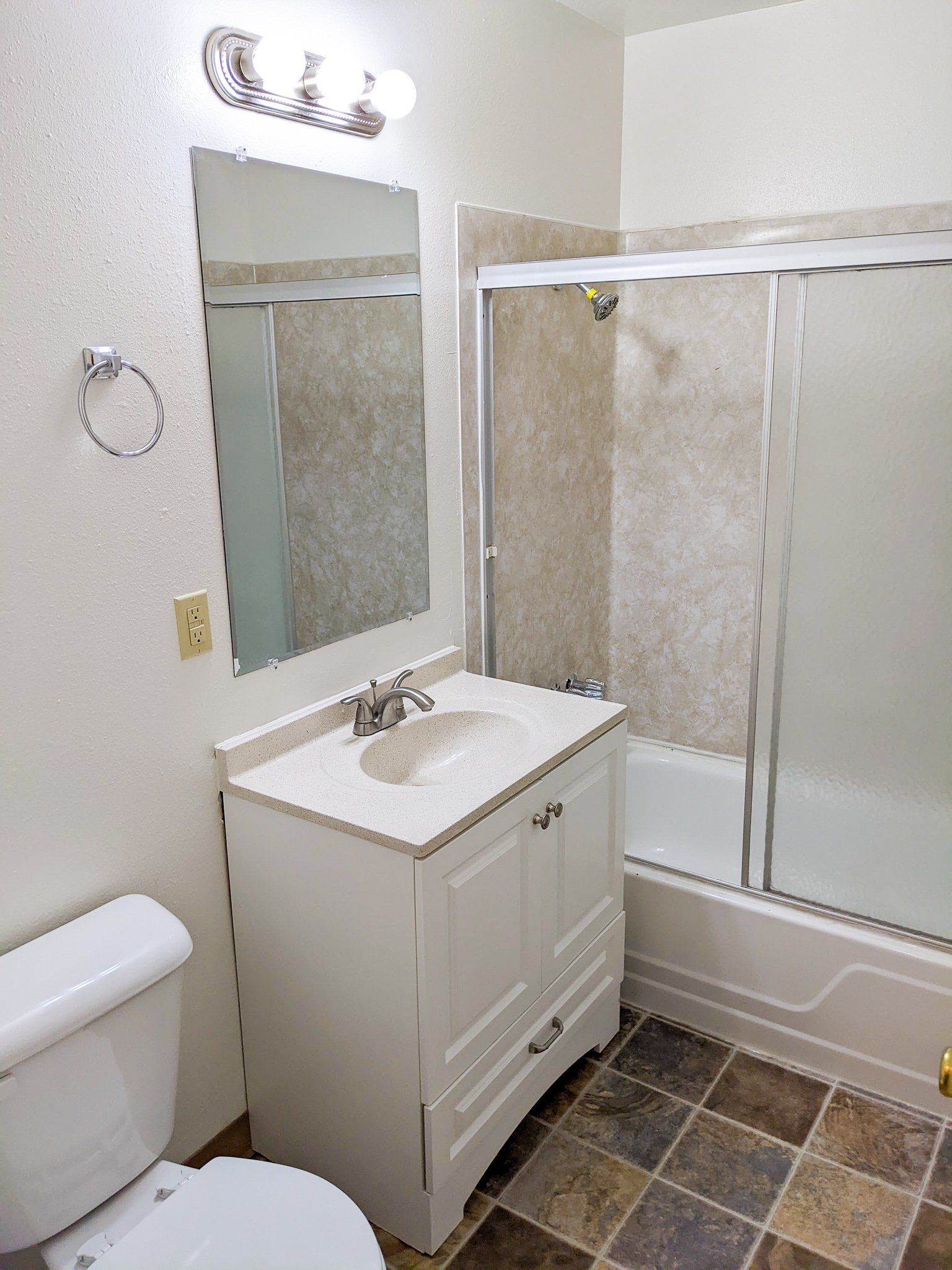 A bathroom with a toilet , sink , and shower.