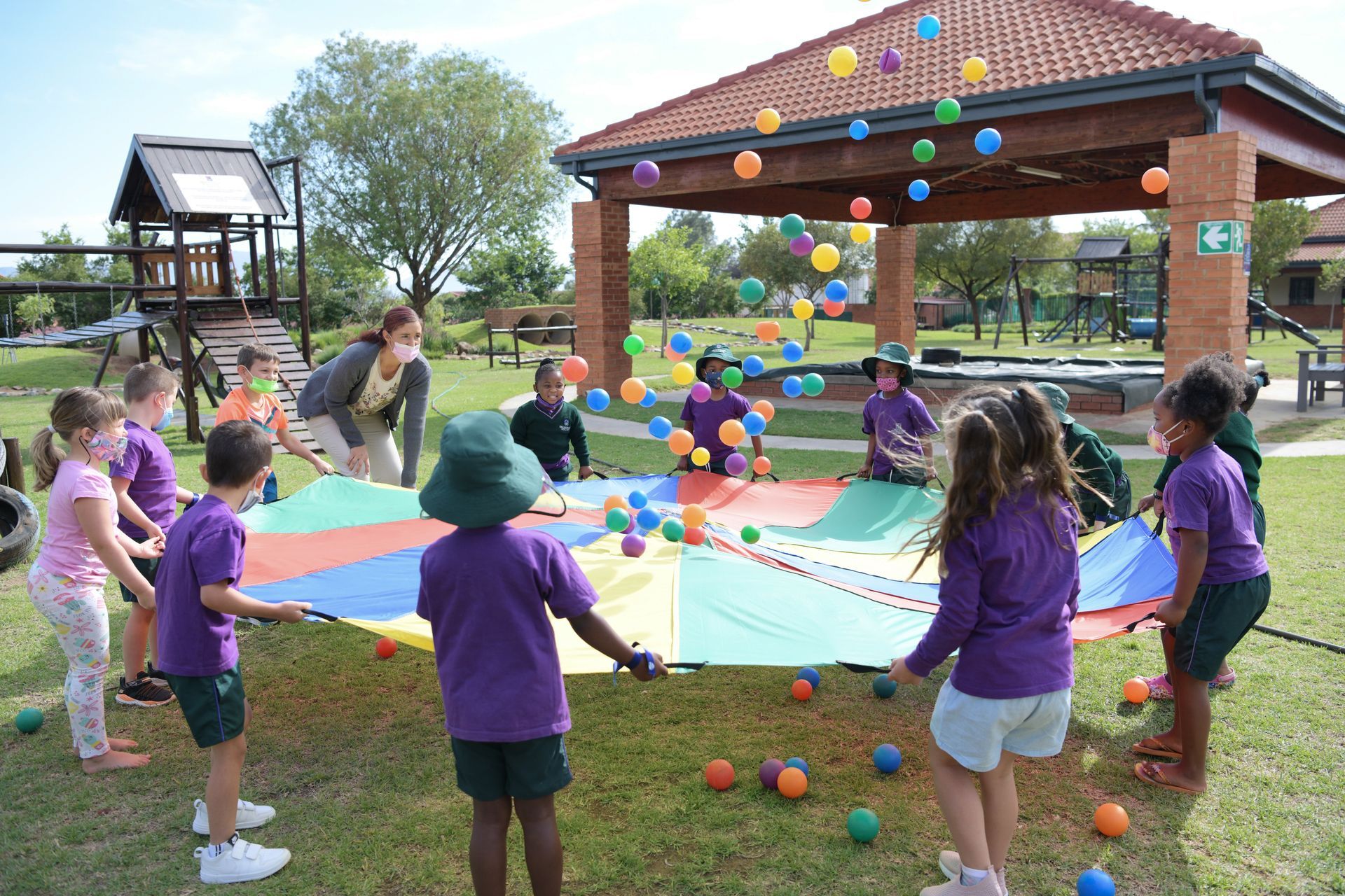 a group of children are playing with a trampoline