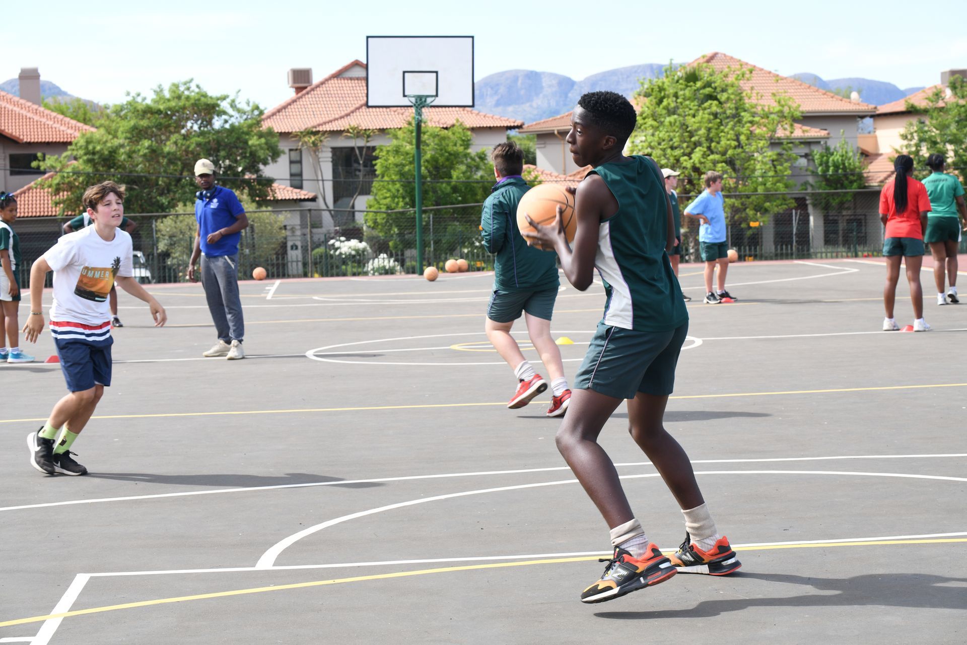 a group of young people are playing basketball on a court .