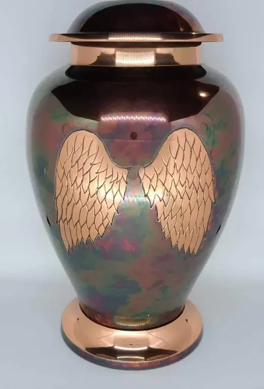 A large urn with wings on it is sitting on a table.