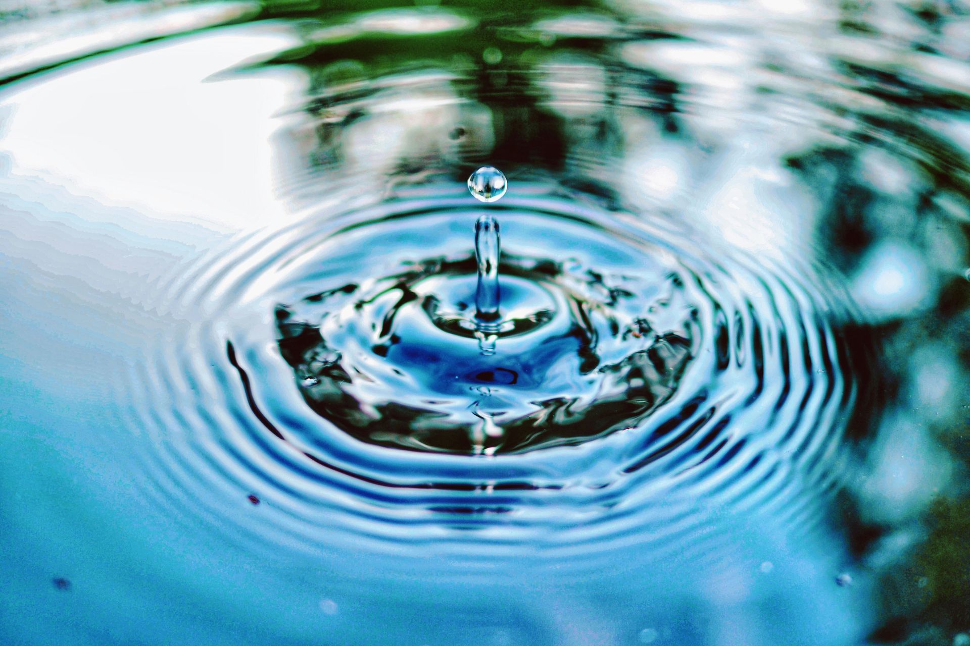 A drop of water is falling into a pool of water