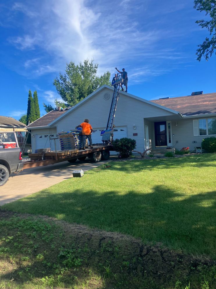 Roofing crew performing tear-off on residential roof