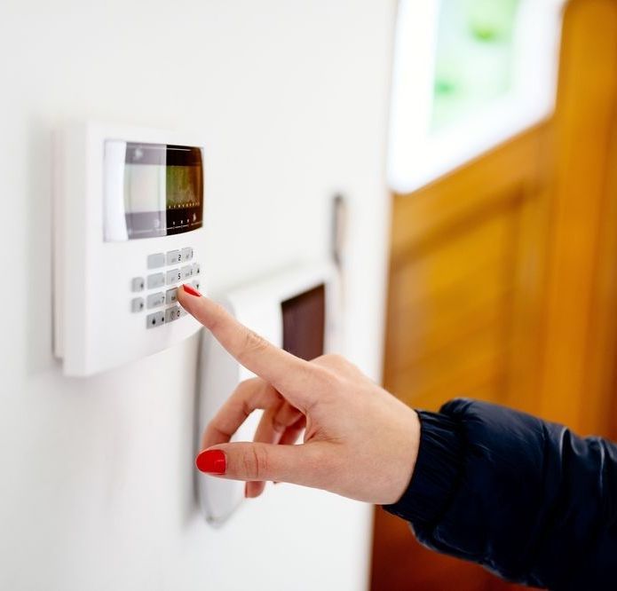 A Woman Is Pressing A Button On A Security System — Grafton Locksmith Service In Grafton, NSW