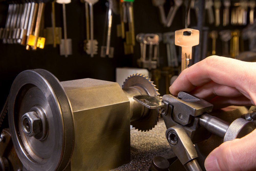 A Person Is Cutting A Key With A Machine — Grafton Locksmith Service In Grafton, NSW