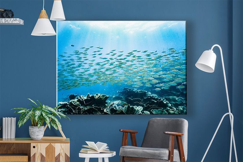 Canvas print on a wall with two people walking on the beach at sunset