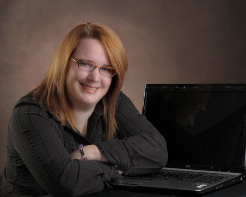 A woman with her arm crossed over a laptop