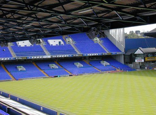 Empty football stadium with bright blue seating rows