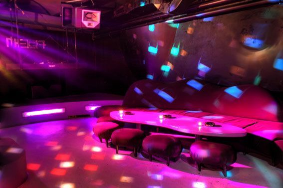Colorful nightclub lounge with neon lights and modern seating area