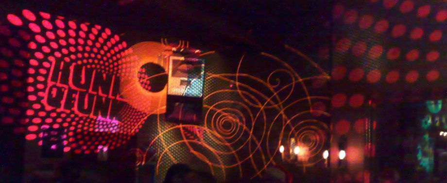 Bar with vibrant wall graphics and swirling disco-inspired lighting