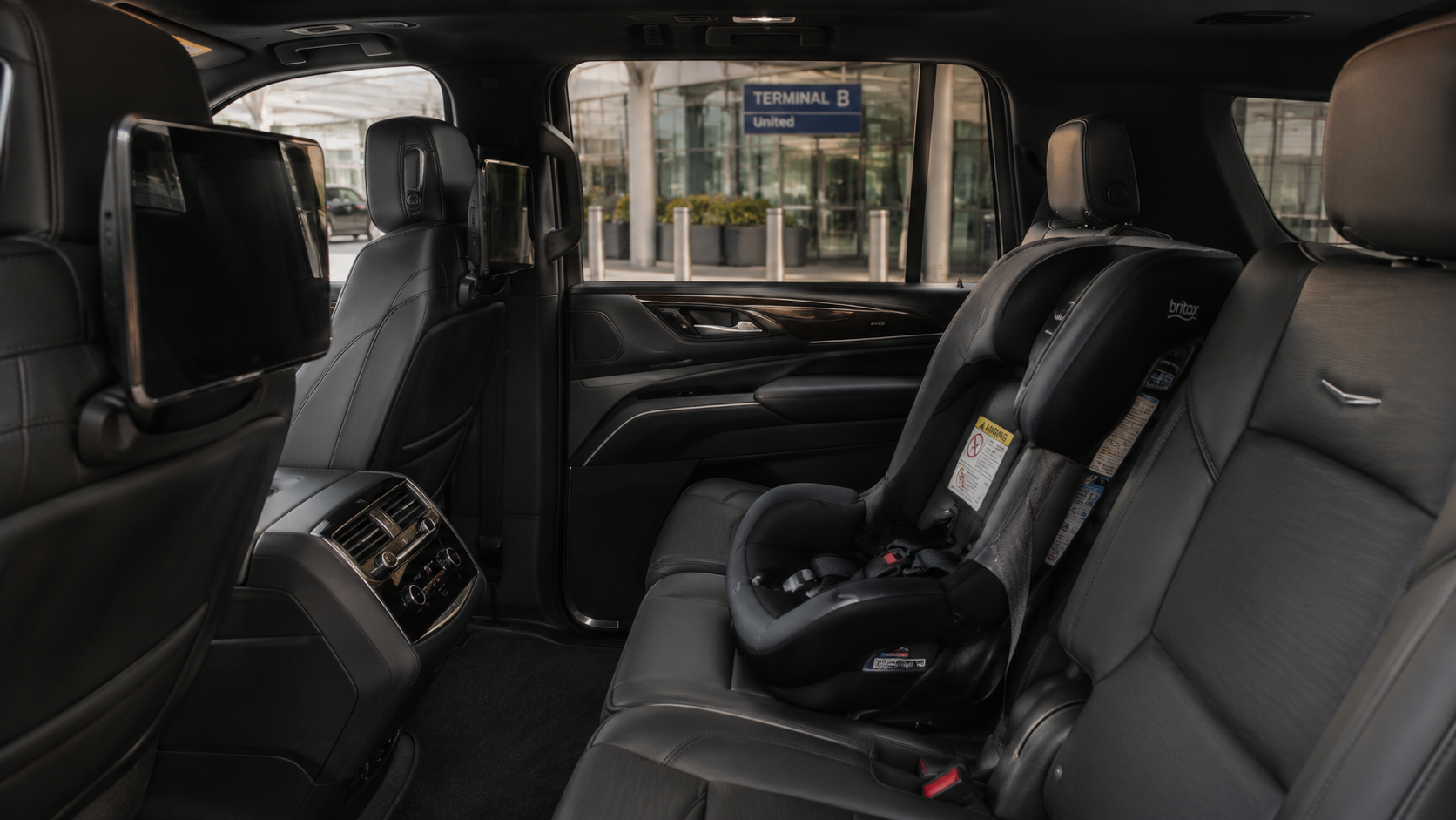 A child safety seat in the back of a luxury SUV.