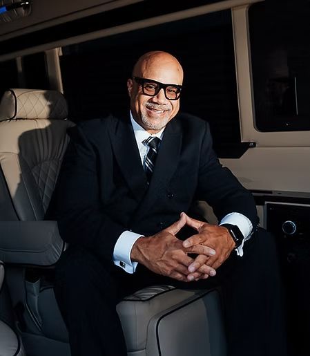 Man in suit smiles, sitting in a luxury van interior. Man in suit smiles, sitting in a luxury van interior.