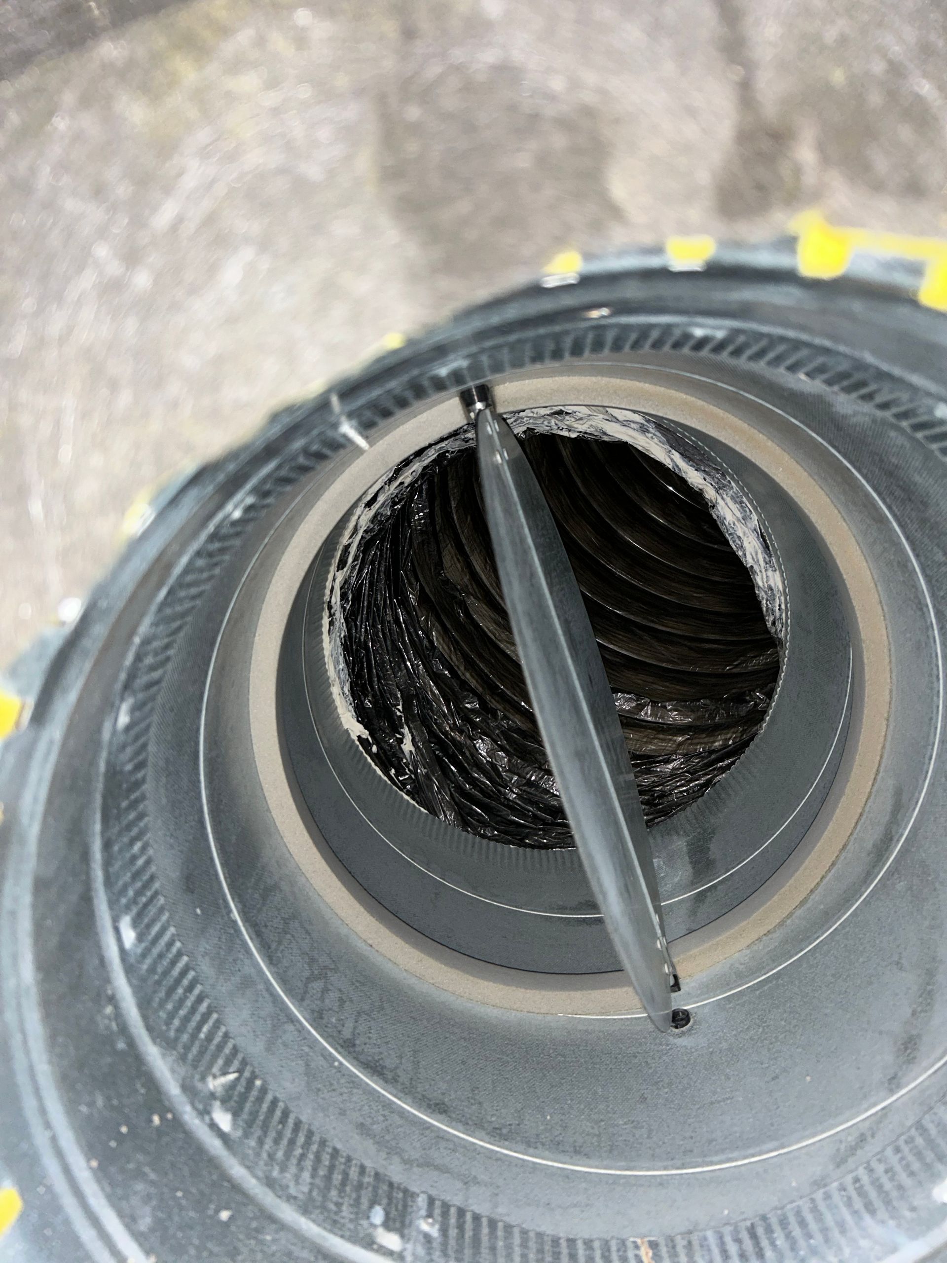 Man in black uniform repairing HVAC system ductwork.
