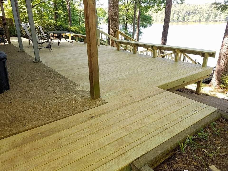 Wooden ramp and deck leading to a lakeside platform among trees