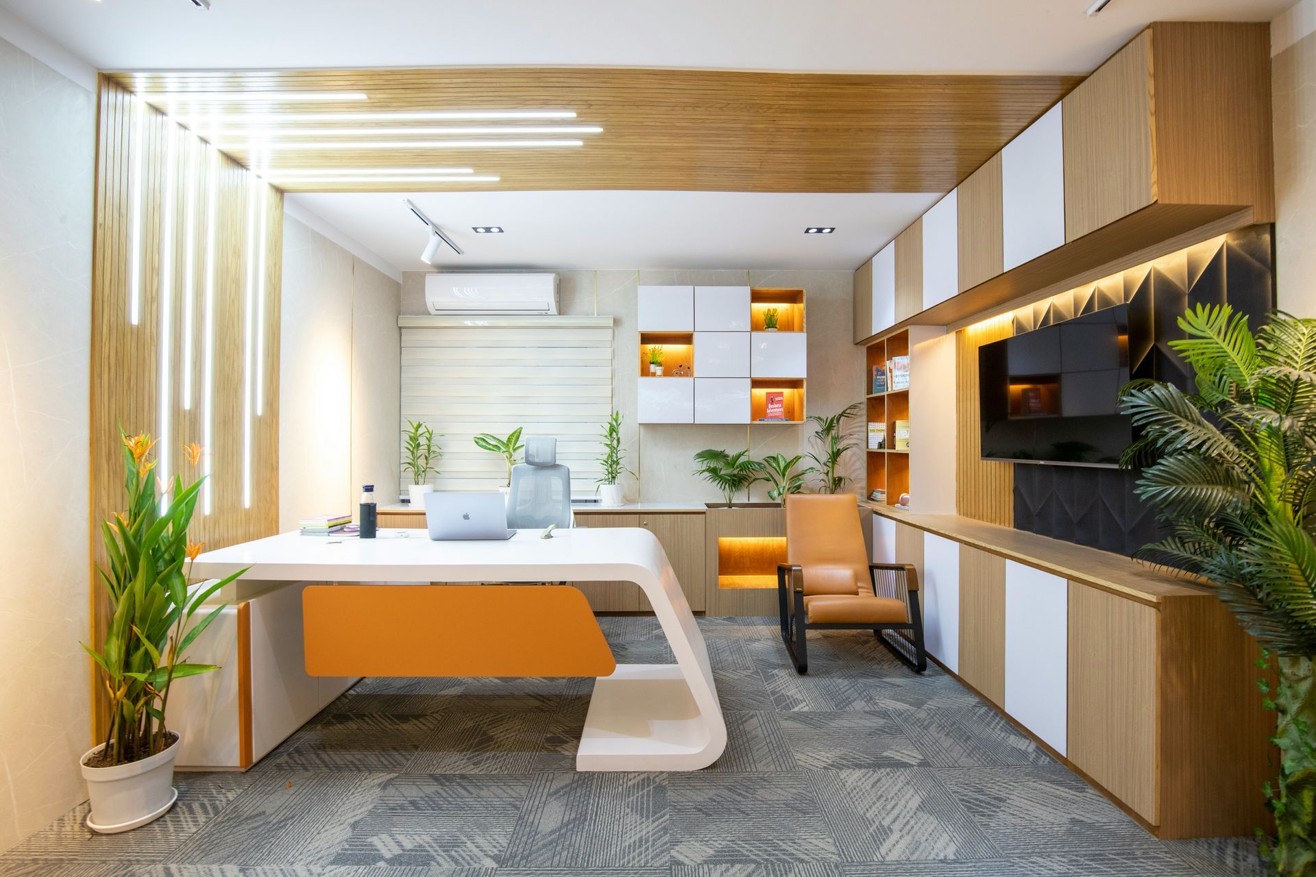Modern office reception area with wood accents, white desk, orange chair, and indoor plants