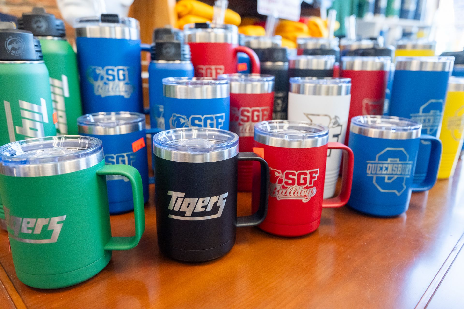 A bunch of mugs are sitting on a wooden table.