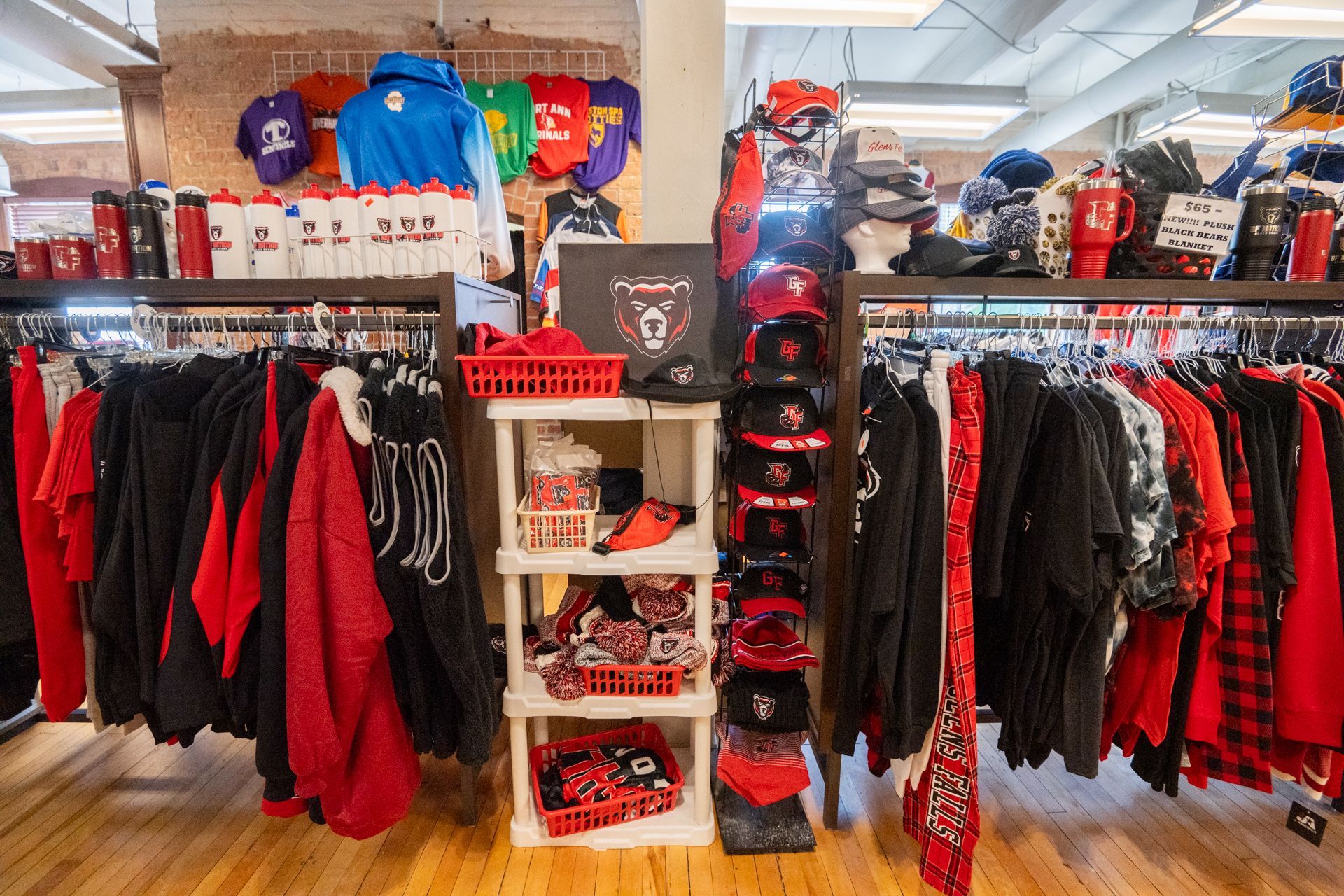 A store filled with lots of red and black clothes and hats.