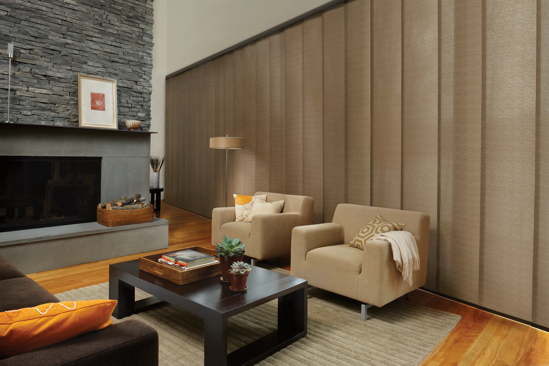 A living room with two chairs , a coffee table and a fireplace.
