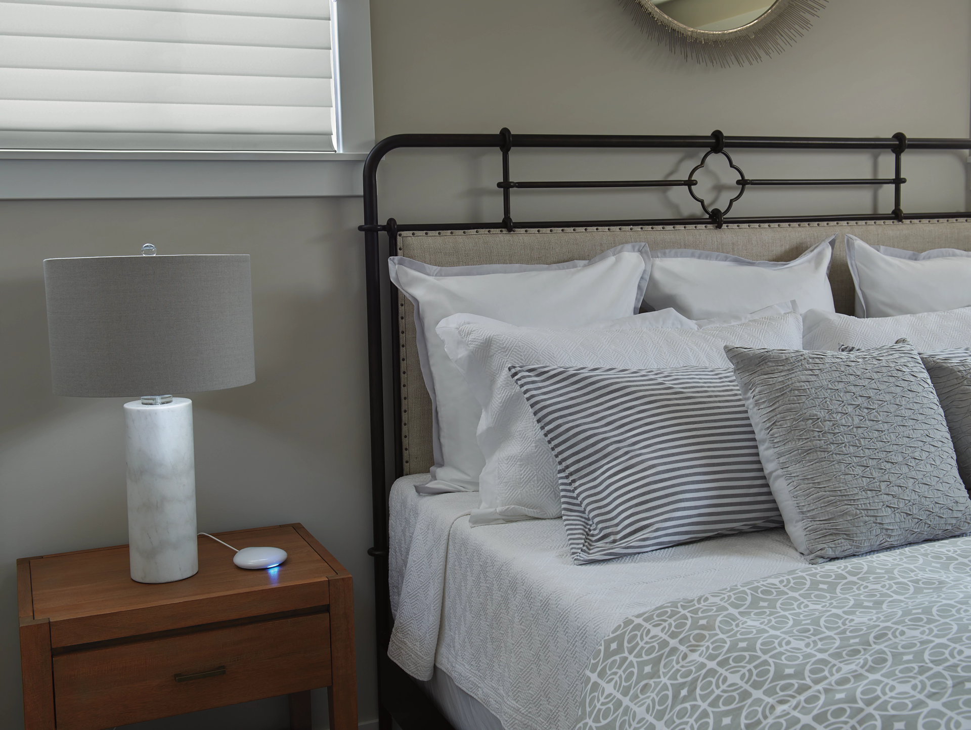 A bedroom with a bed , nightstand and lamp