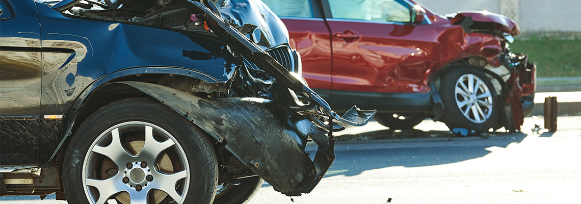 Two cars with heavy front-end damage after a collision on a Houston street