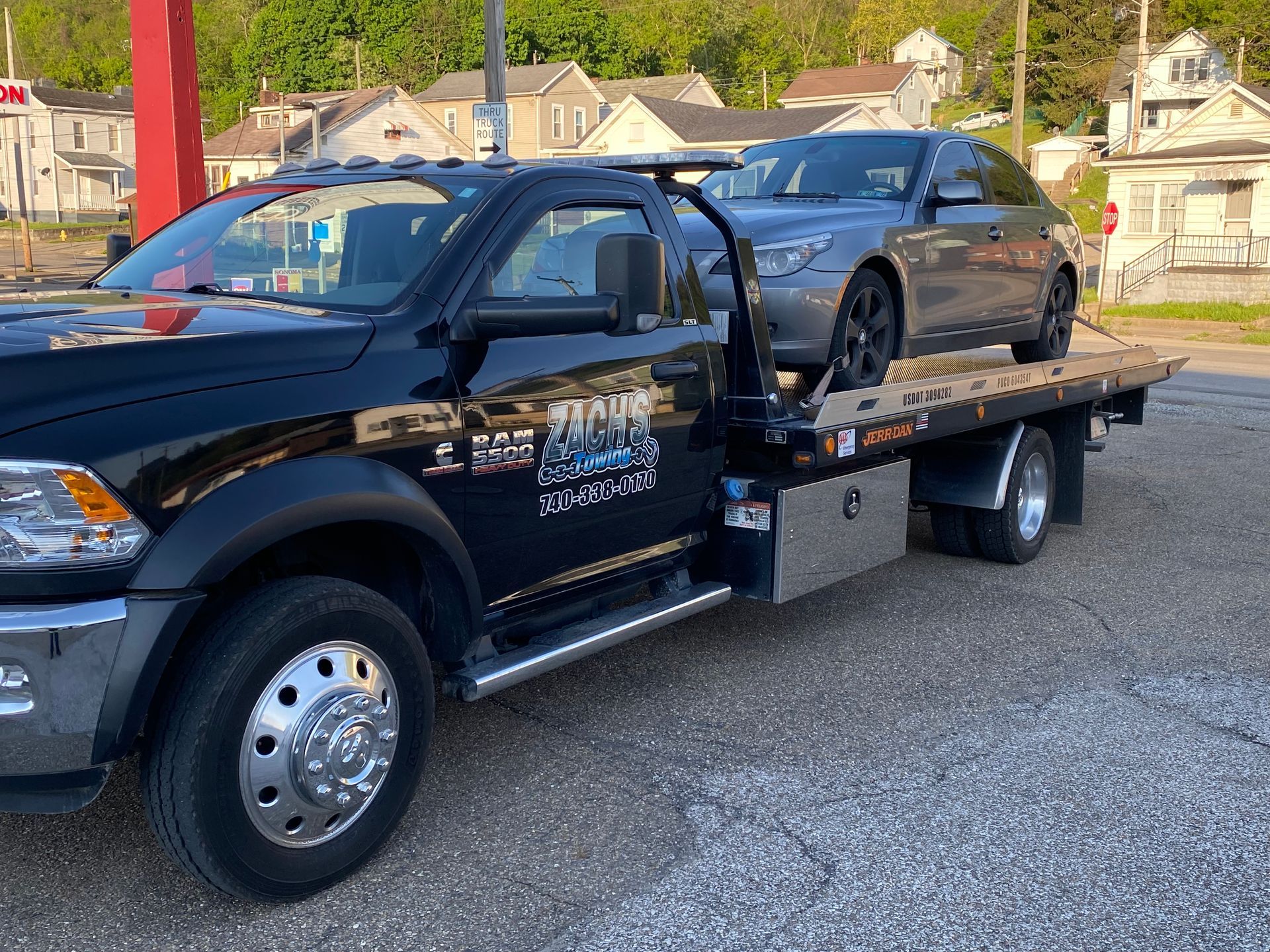 A tow truck with a car on the back of it.