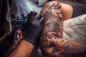 Realizzazione di tatuaggio su braccio maschile