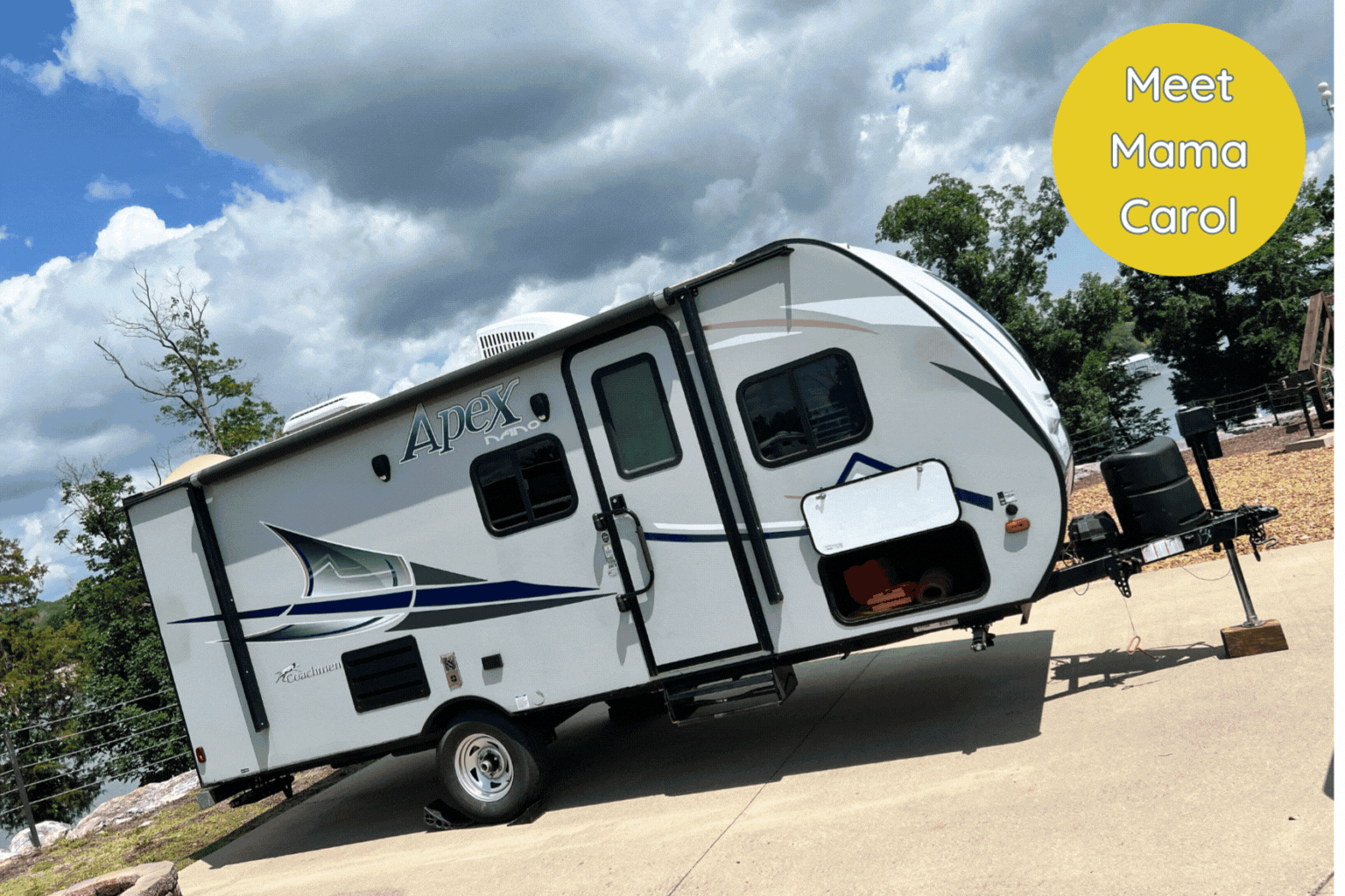 A small white rv is parked in a parking lot.