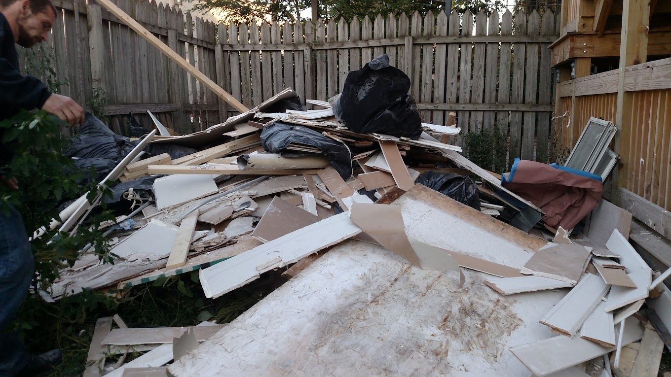 A man is standing next to a pile of cardboard.