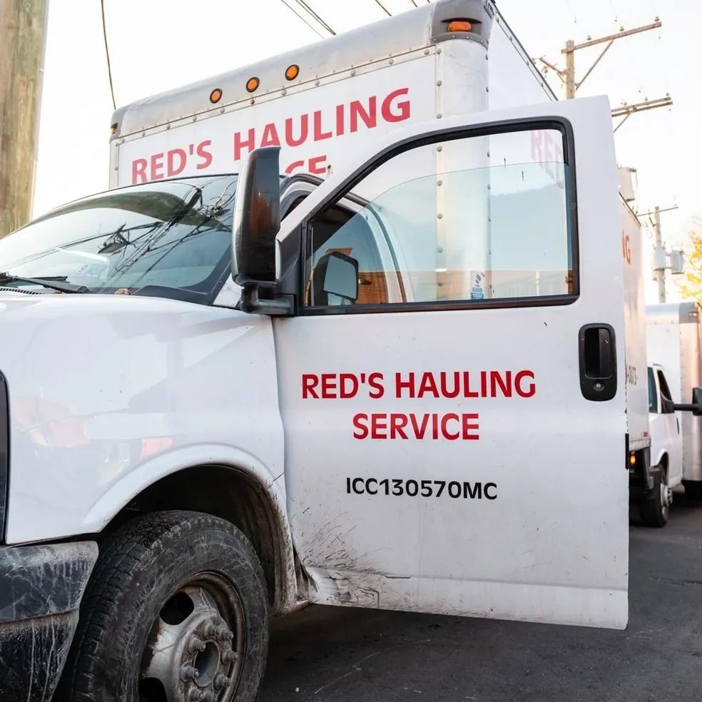 A truck that says red 's hauling service on the back