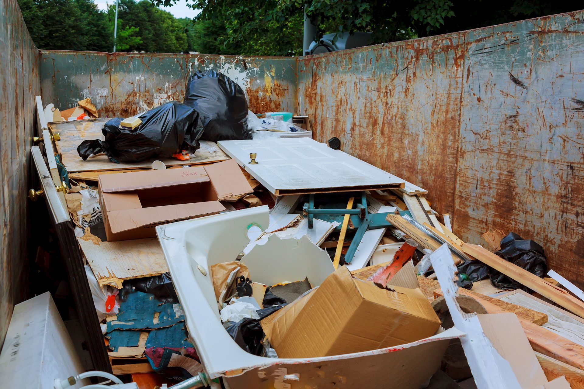 A dumpster filled with lots of trash and junk.