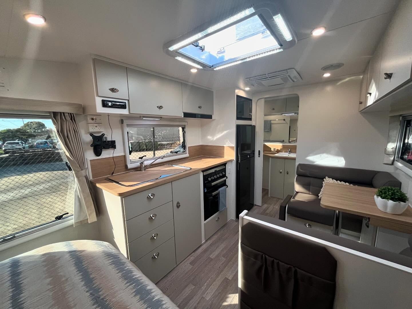 A Bedroom in a Camper With a Bed and a Window — J & D Caravans In Tamaree, QLD
