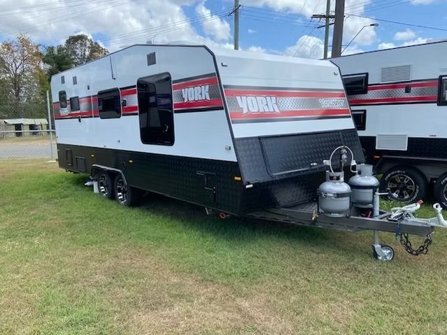 A Black and White Trailer is Parked in a Grassy Field — J & D Caravans In Tamaree, QLD