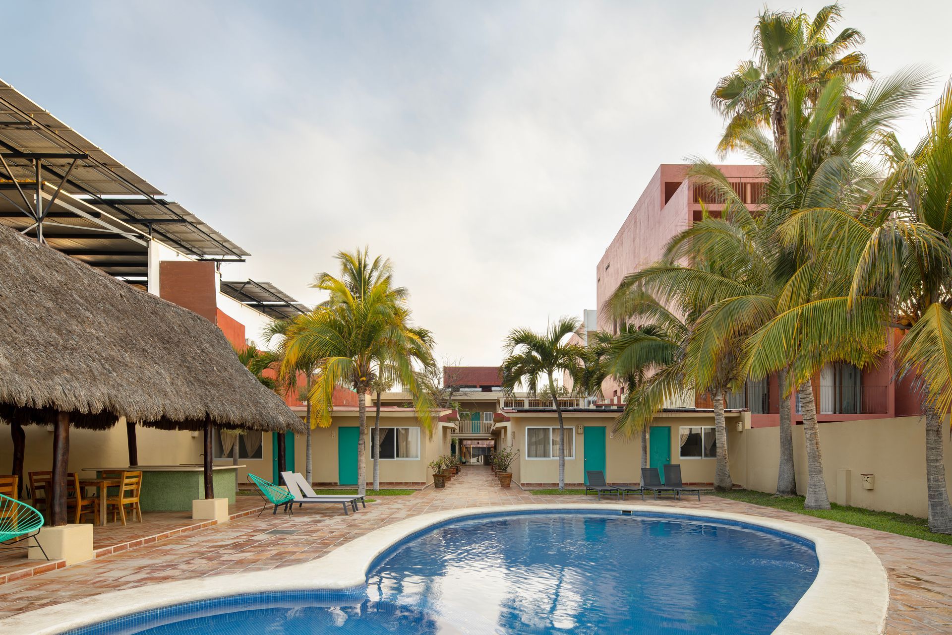 A large swimming pool surrounded by palm trees and buildings
