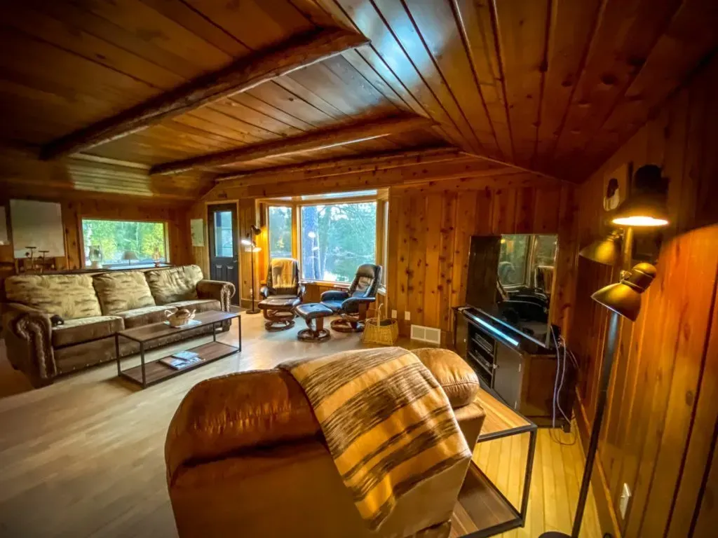 A living room with a couch , chair , coffee table and television.