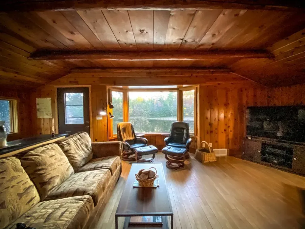 A living room with a couch , chair , coffee table and television.