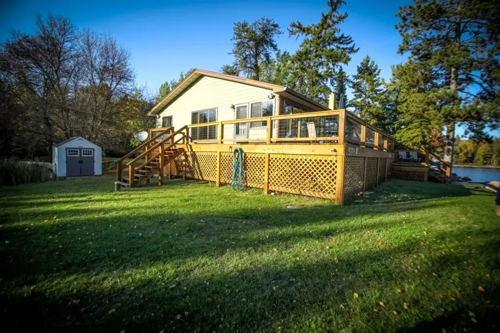 A house with a large deck and a shed in the backyard.