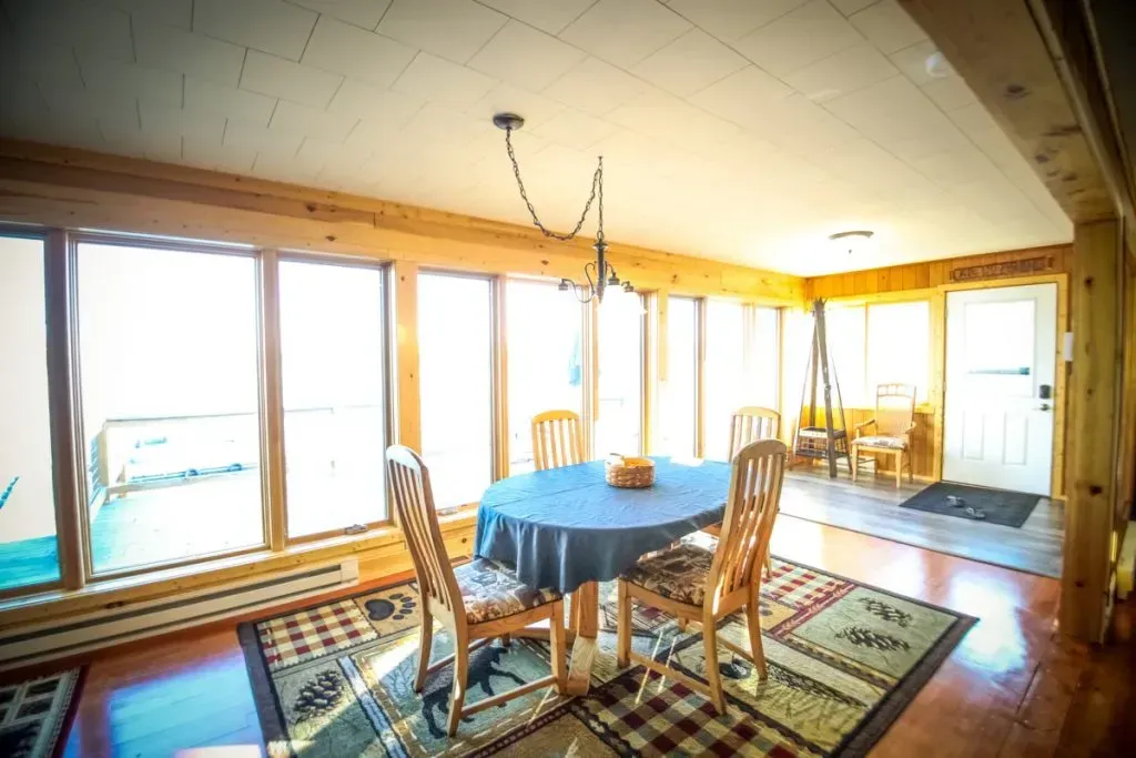 A dining room with a table and chairs and a rug