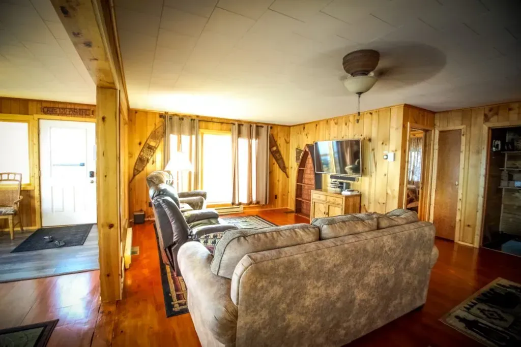 A living room with a couch , chairs , and a ceiling fan.