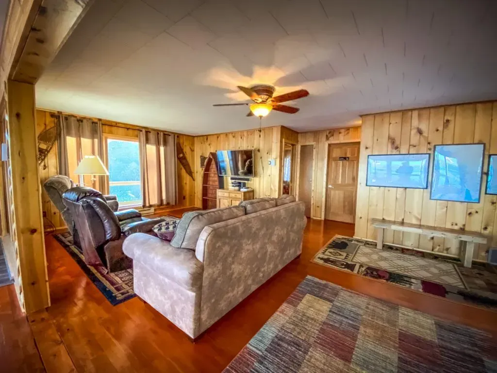 A living room with a couch , chairs , and a ceiling fan.