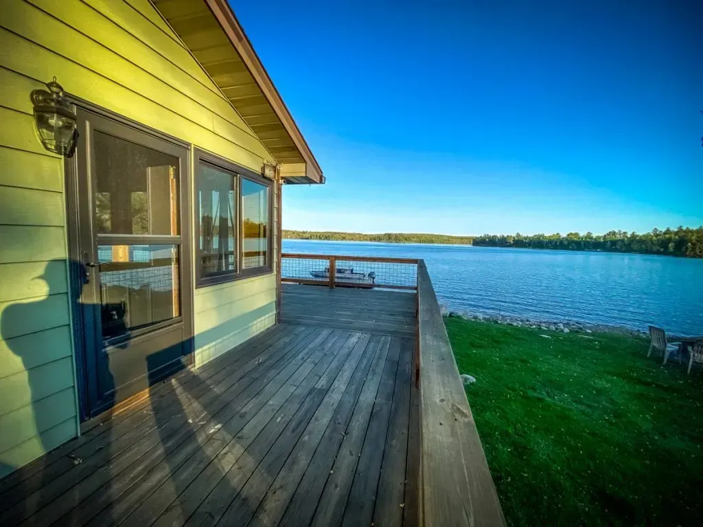 A house with a wooden deck overlooking a lake