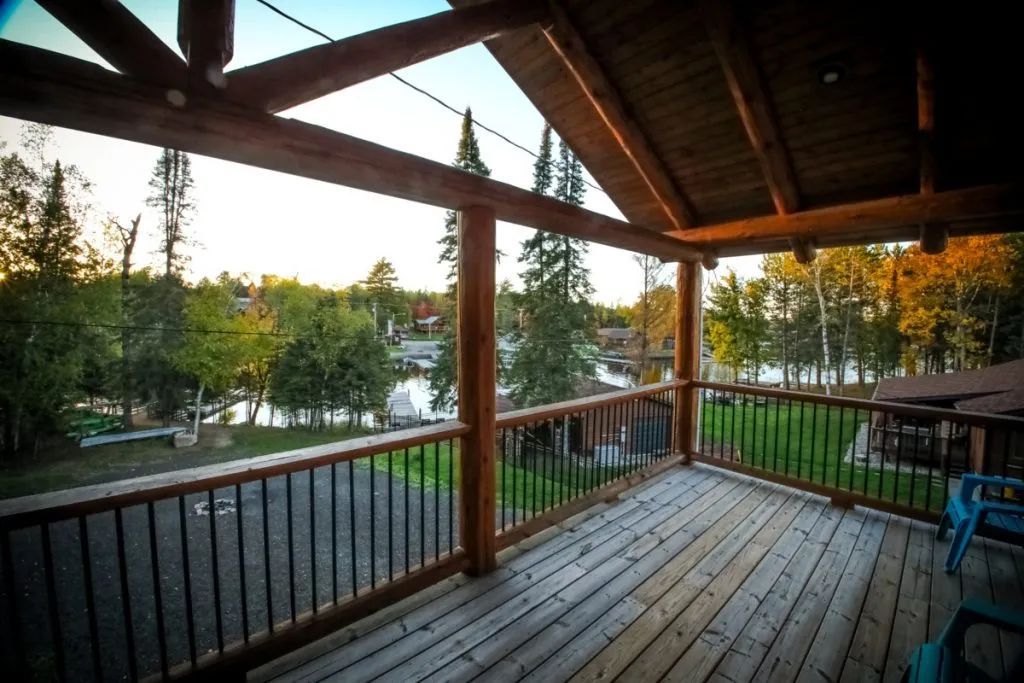 A deck with a view of a lake and trees