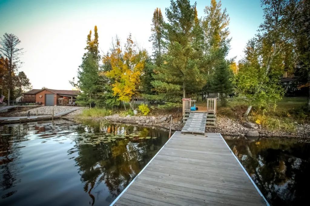 There is a dock in the middle of a lake surrounded by trees.