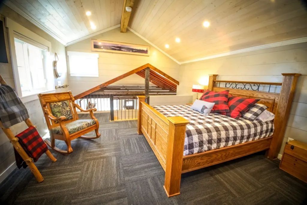 A bedroom with a king size bed and a rocking chair.