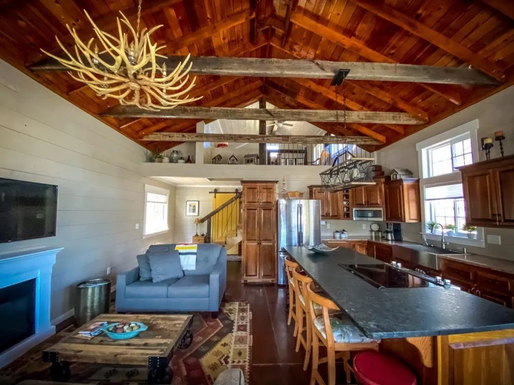 A living room with a couch , table , fireplace and kitchen.