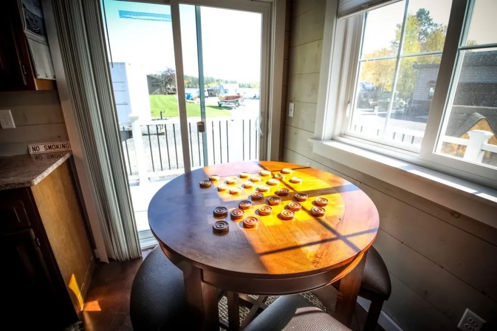 A round table with a game on it in front of a window.