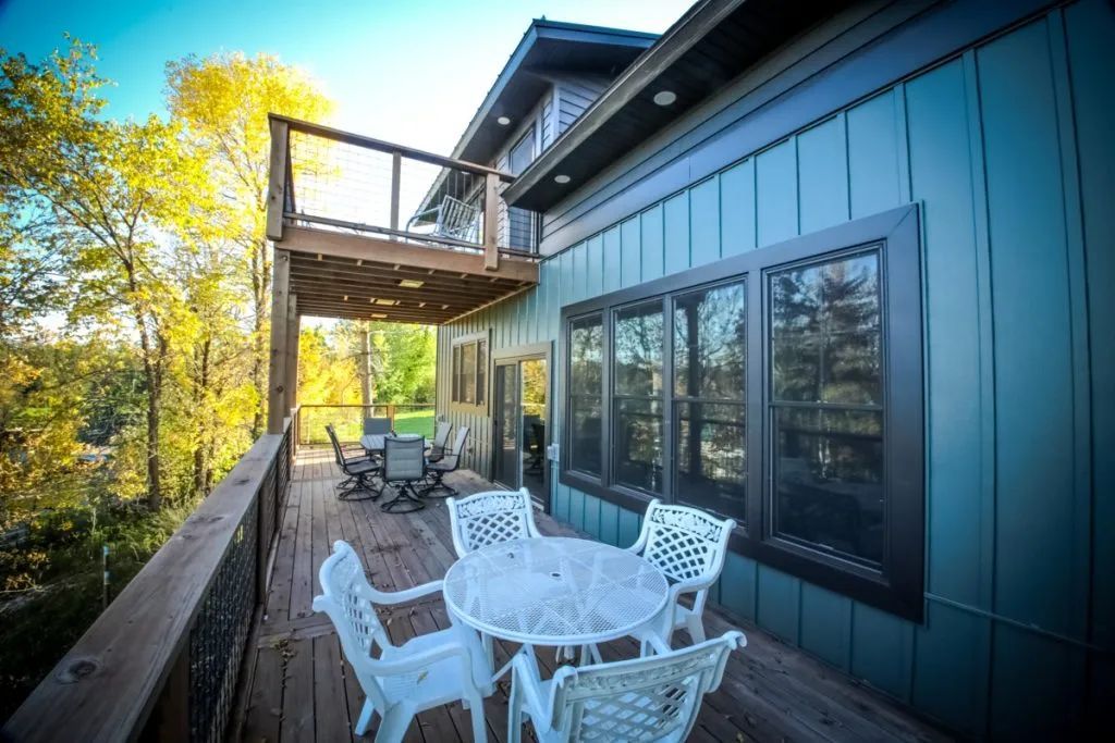 There is a large deck with a table and chairs on it.