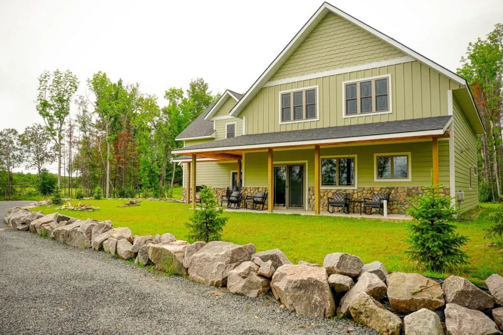 A large house with a stone wall in front of it