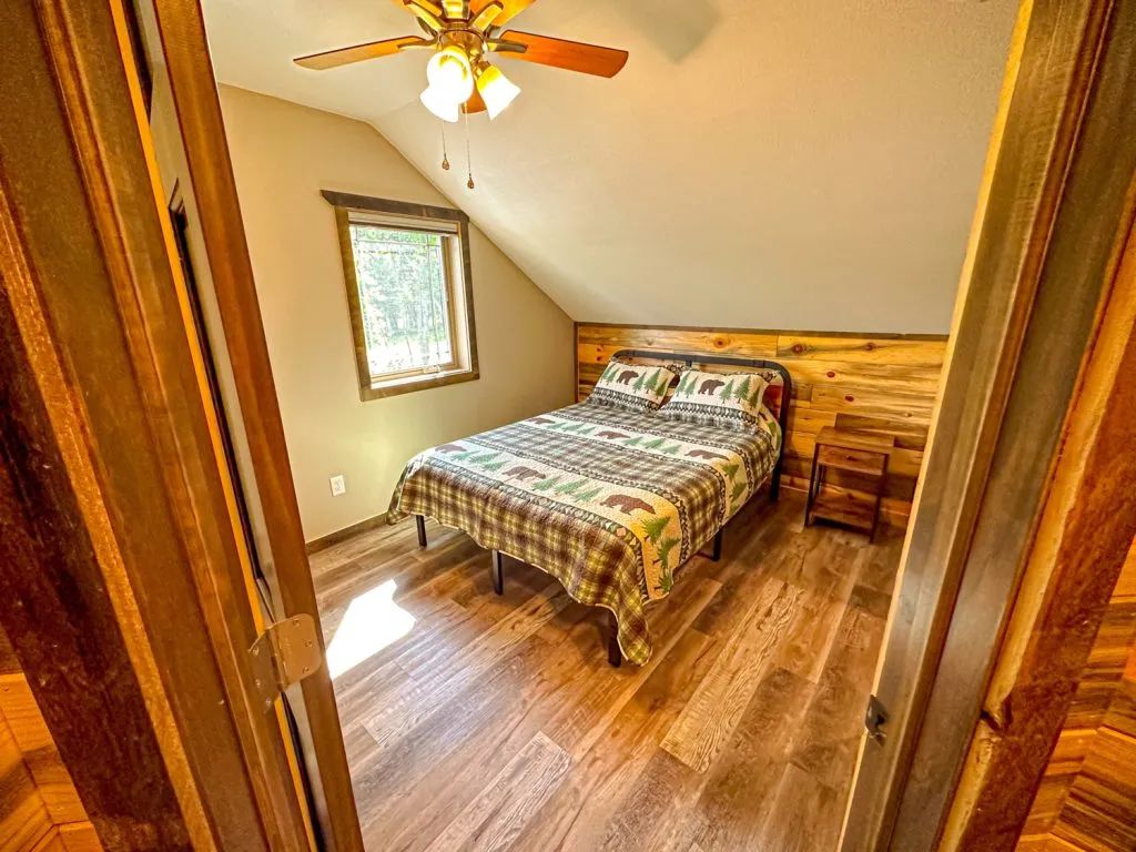 A bedroom with a king size bed and a ceiling fan.