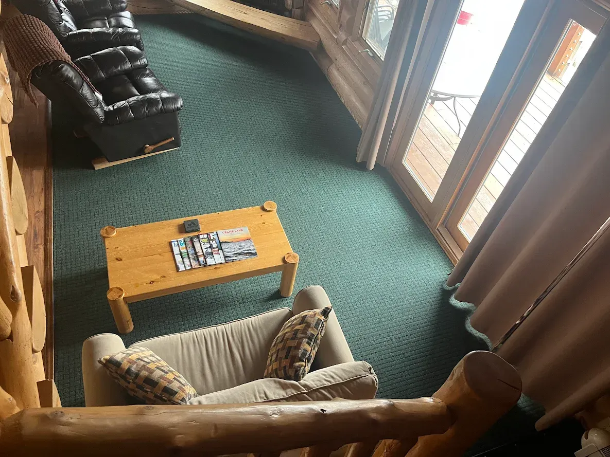 A bedroom in a log cabin with bunk beds and a fan.